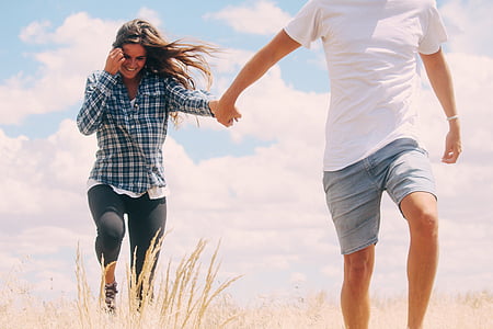 man wearing white t-shirt holding the hand of the woman wearing blue and white plaid dress shirt thumbnail