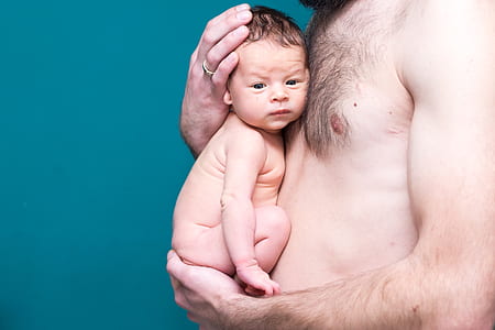 man holding baby near his chest thumbnail