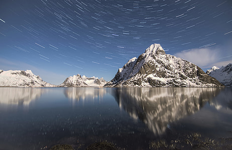 landscape photography of body of water and gray rock mountains covered with snow at daytime thumbnail