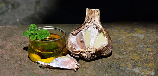 garlic bulb beside glass cup on gray concrete thumbnail