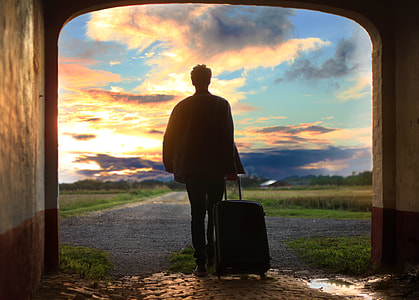 man walking while holding luggage bag thumbnail