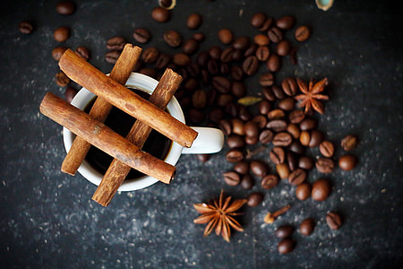 shallow focus of brown coffee beans beside white ceramic mug thumbnail