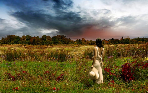 woman wearing white sleeveless maxi dress near red petaled flowers thumbnail