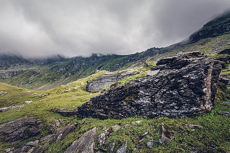 grass covered mountain under gray cloudy sky during daytime thumbnail