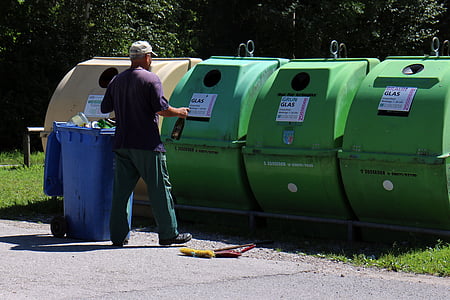 man standing in front of garbage bins thumbnail