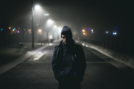 man standing on road near road lamp thumbnail