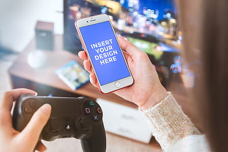 Player with PS4 gamepad use his smartphone at home. Free PSD Mockup thumbnail