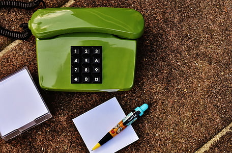 green phone beside pen and paper thumbnail