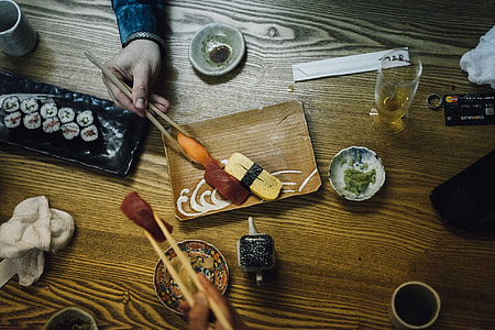 person using chopsticks to pickup food on table thumbnail