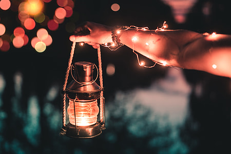 person holding black kerosene lantern thumbnail