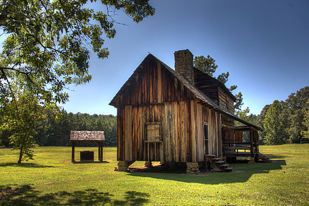 brown wooden house on green grass field thumbnail