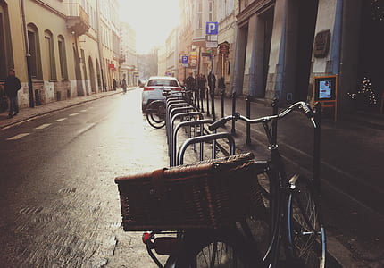 black commuter bike near white vehicle on road between building at daytime thumbnail