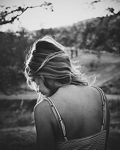 grayscale of woman in stripe spaghetti strap top facing road and trees thumbnail