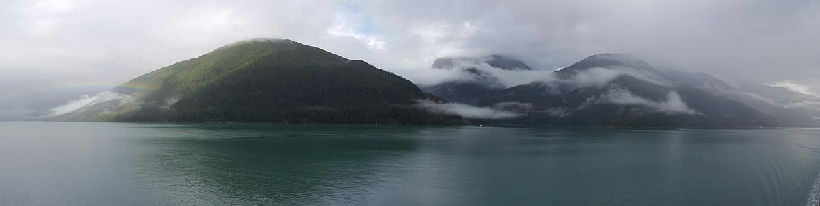 cloudy mountain surrounded by body of water thumbnail