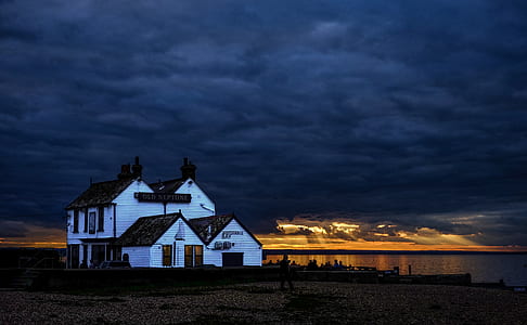 white wooden 2-storey house near body of water thumbnail
