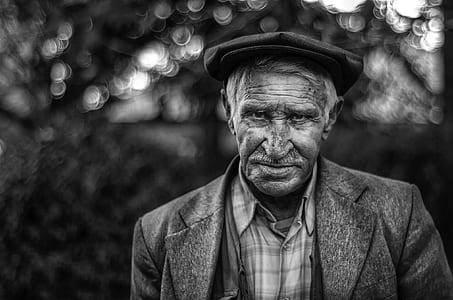 grayscale photo of man wearing flat cat and notched lapel suit jacket thumbnail