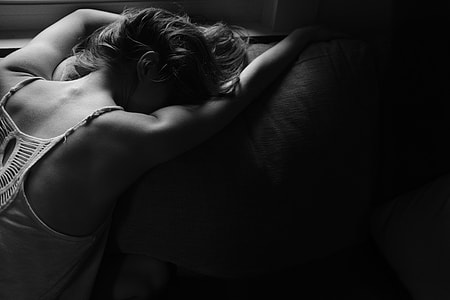 woman in white spaghetti strap top lying on pillow thumbnail