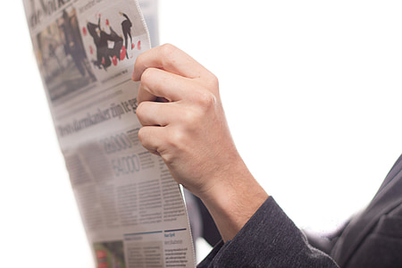 person holding white newspaper thumbnail