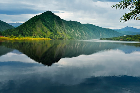 calm water near green mountain at daytime thumbnail