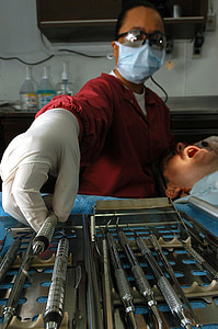 person in red top wearing white plastic glove holding operating tool thumbnail