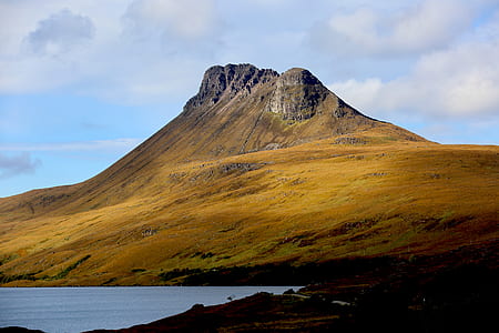 body of water beside rock mountain thumbnail