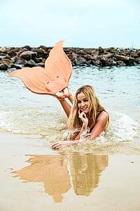 photography of girl lying on seashore with mermaid fins at daytime thumbnail