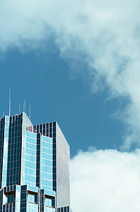 high rise building under white clouds and blue sky thumbnail