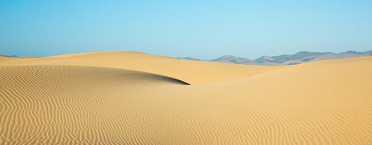 beige desert under blue sky at daytime thumbnail