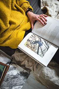 Young woman reading a magazine in bed thumbnail