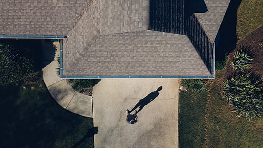 person standing near outdoor beside brown building thumbnail