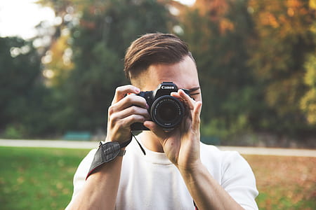man holding black bridge camera while taking photo thumbnail