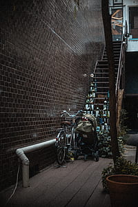 chrome-colored bicycle and brown stroller near wooden stairs thumbnail