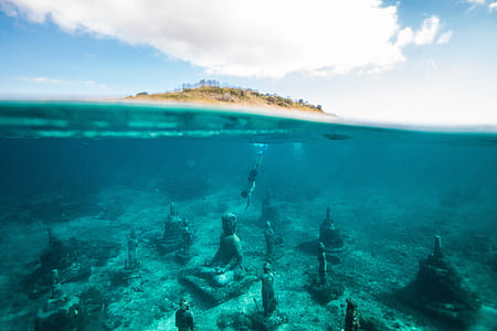 underwater photo of person swimming on concrete statue thumbnail
