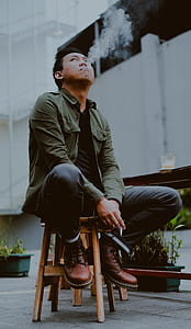 man smoking cigarette sitting on barstool thumbnail
