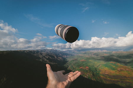 person throwing black and gray container under blue sky thumbnail