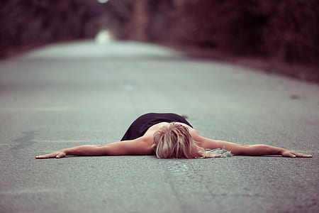 person lying in the middle on asphalt road thumbnail