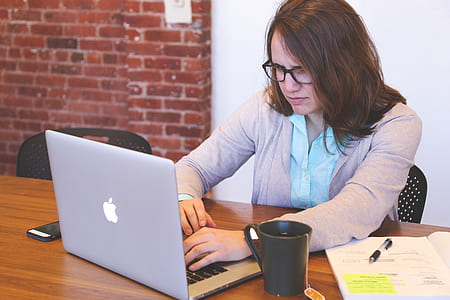 woman using silver MacBook Air on the table thumbnail