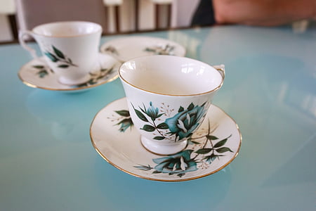 two white-and-green ceramic teacups with saucers thumbnail