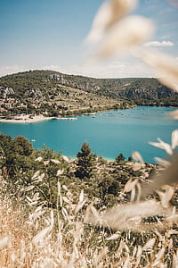body of water surrounded by mountains during daytime thumbnail