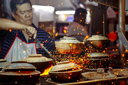 man in blue shirt and white apron cooking thumbnail