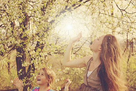 woman and girl smiling near tree during day time thumbnail