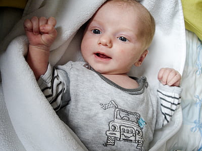baby lying on white swaddle thumbnail