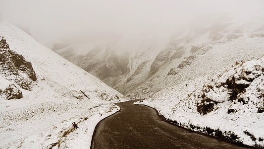 asphalt road beside of mountain covered by snow thumbnail
