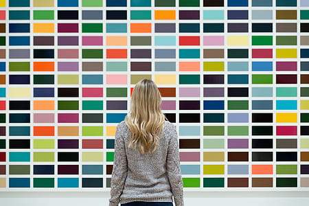 woman in gray sweatshirt standing in front of multicolored wall thumbnail