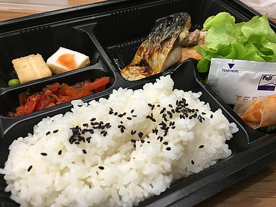 cooked rice with seeds, meat, and lettuce inside black plastic container thumbnail