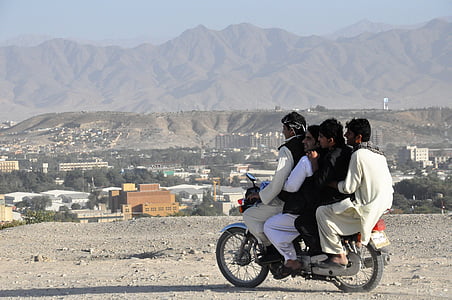 four men riding motorcycle on dirt road thumbnail