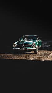 green Mercedes-Benz coupe on road thumbnail
