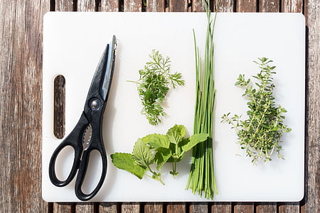 flat lay photography of black handled shears and four spices on white chopping board thumbnail