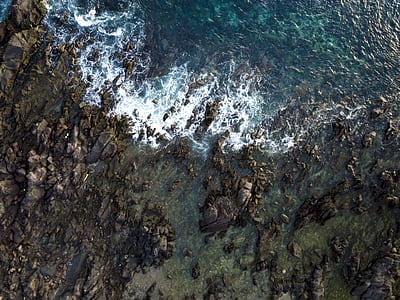 aerial photography of rocks on body on water thumbnail