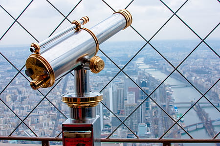 gray and brown telescope beside fence at daytime thumbnail